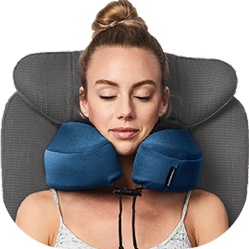 Woman using an indigo blue Evolution S3 travel neck pillow with a gray headrest on a white background